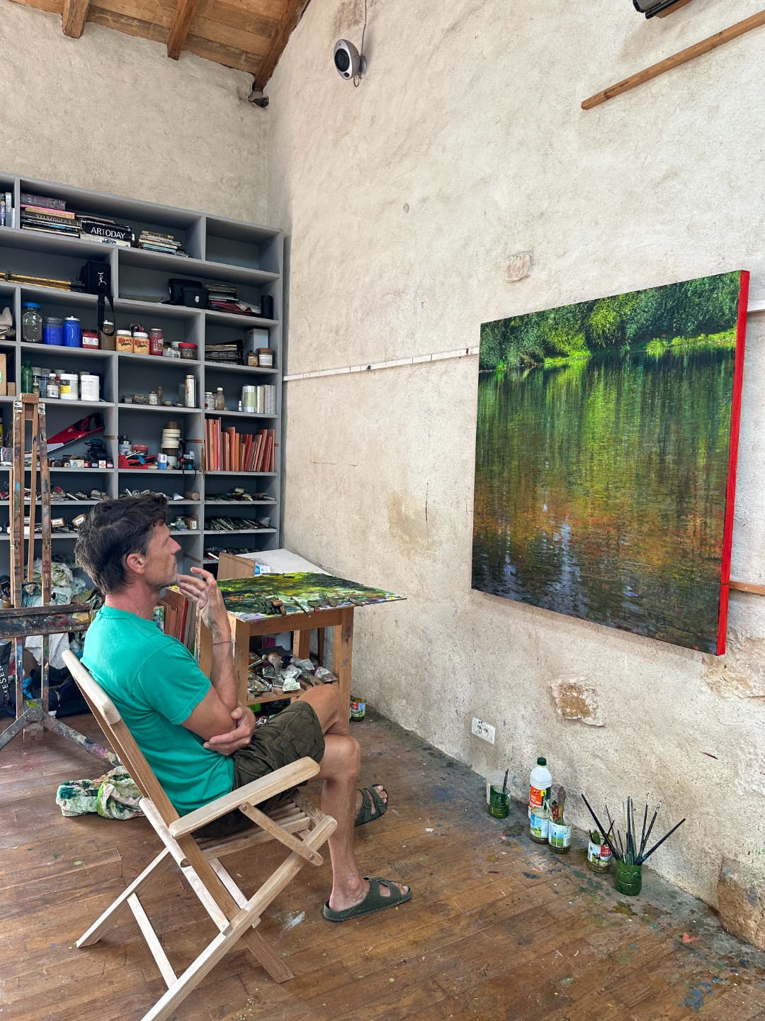 Andrew Gifford in his studio, seated beside the finished painting